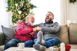 A senior man and his father laugh and smile during a holiday gathering