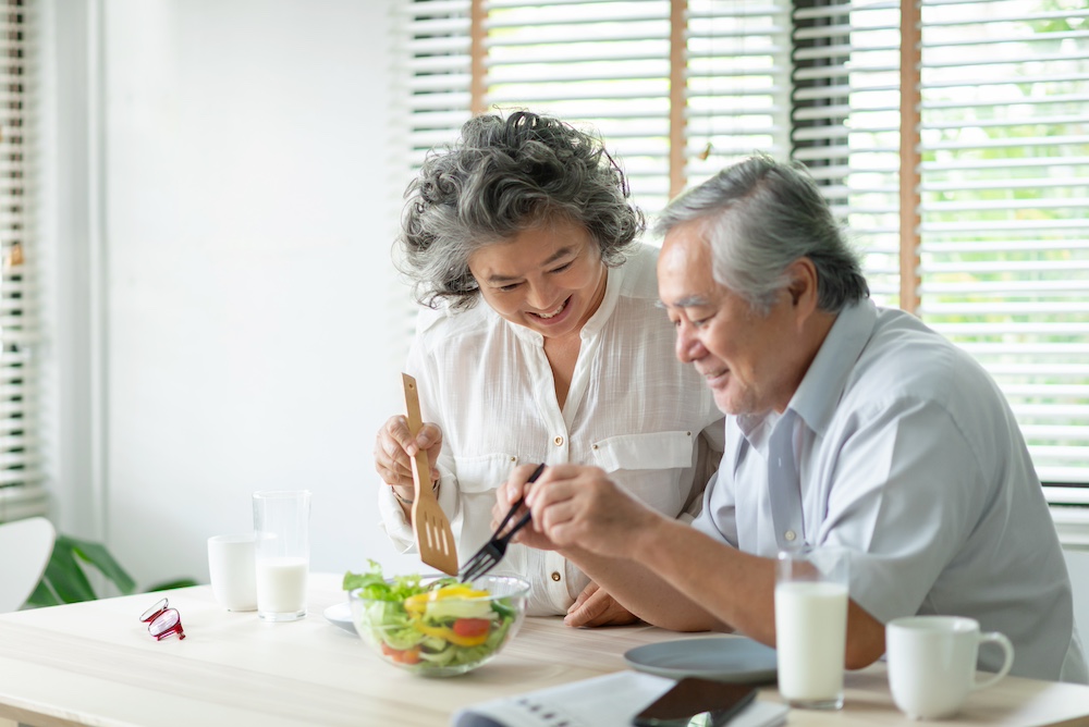 A happy senior couple enjoying a salad together